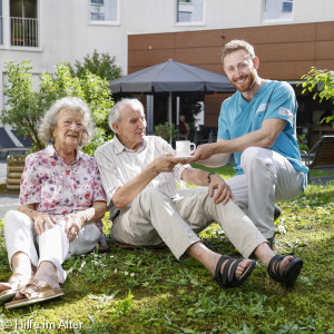 Altenpfleger mit Senioren im Garten