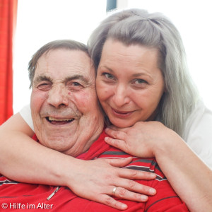 Altenpflegerin umarmt Senior
